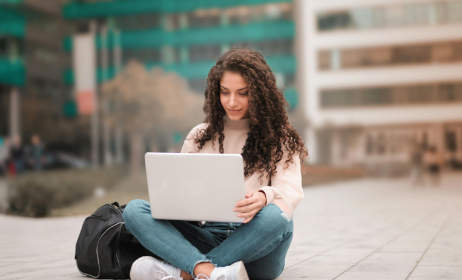 Working at laptop sitting on street