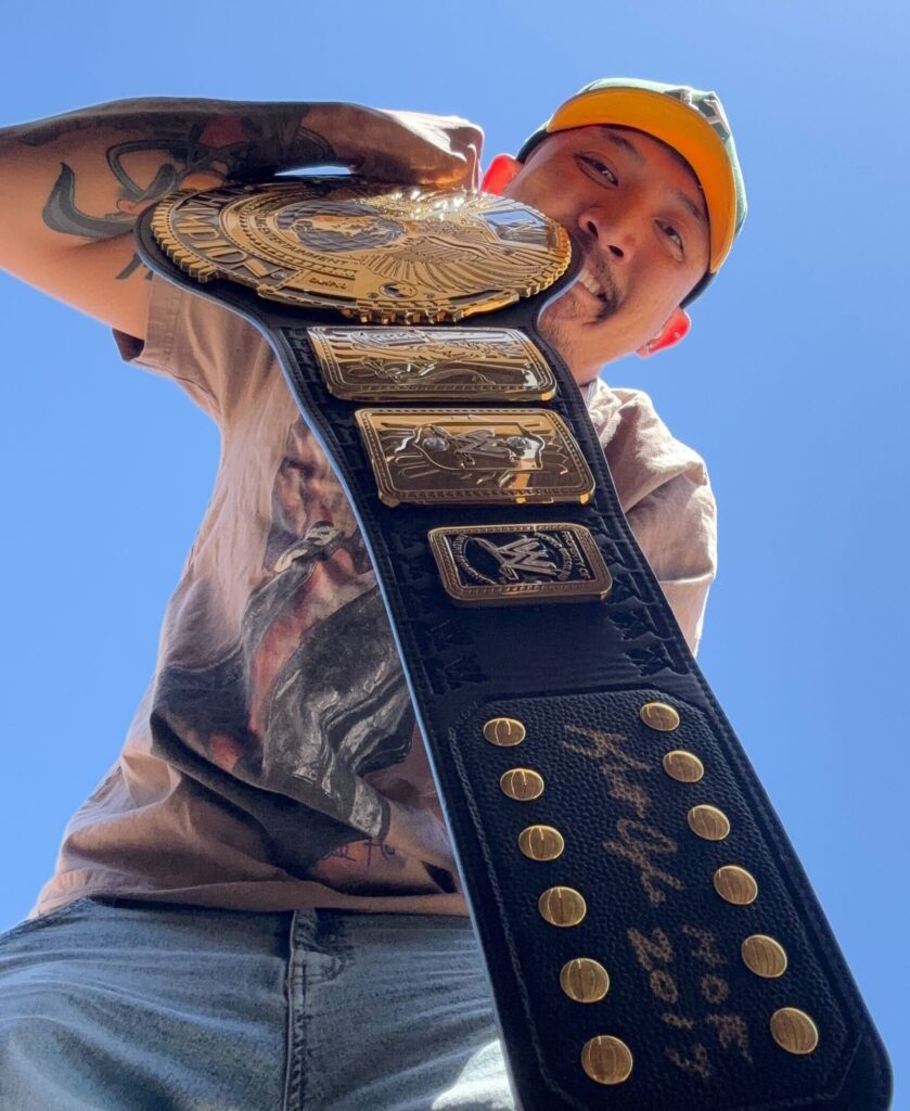 Man holding wrestling belt for employee spotlight