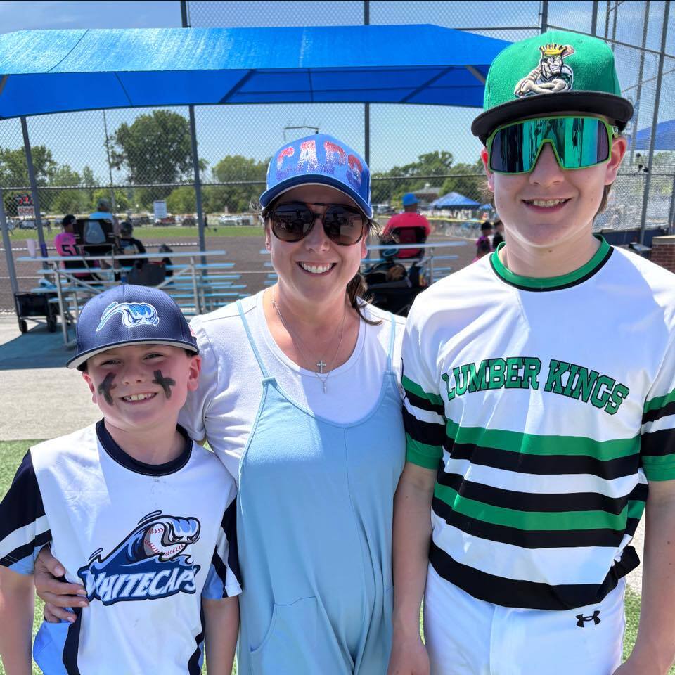 A mom with her two sons at a baseball game