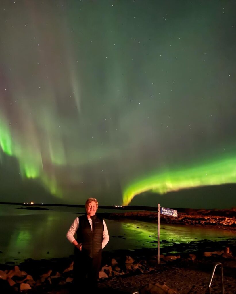 Employee Spotlight of woman standing in front of the Northern Lights 